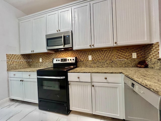 kitchen with light stone counters, white cabinetry, backsplash, and appliances with stainless steel finishes