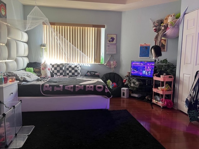 bedroom with dark hardwood / wood-style floors and a closet