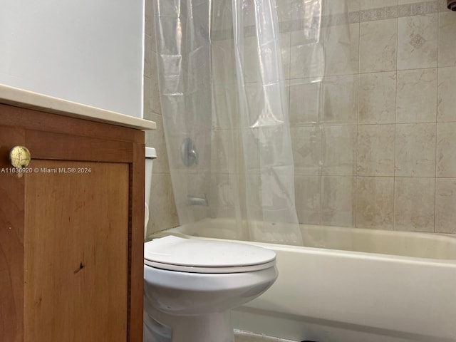 bathroom with shower / bath combination with curtain and toilet