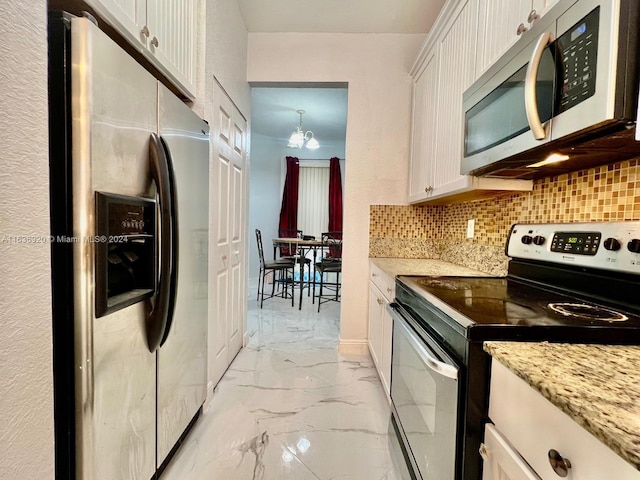 kitchen with white cabinets, appliances with stainless steel finishes, tasteful backsplash, and an inviting chandelier