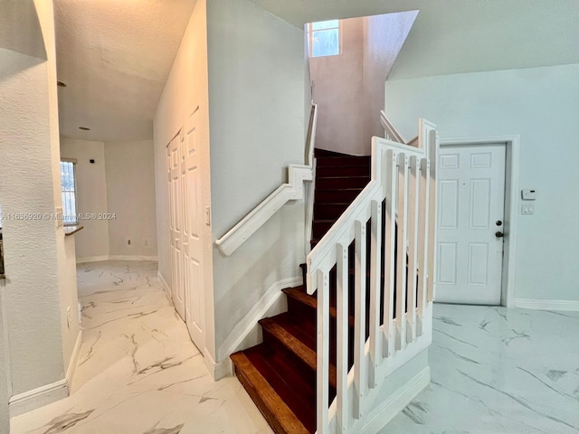 stairs with a textured ceiling