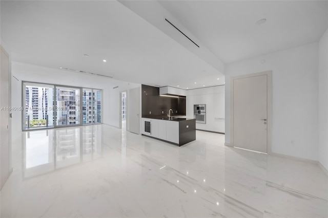 interior space with white cabinets, sink, and light tile patterned floors