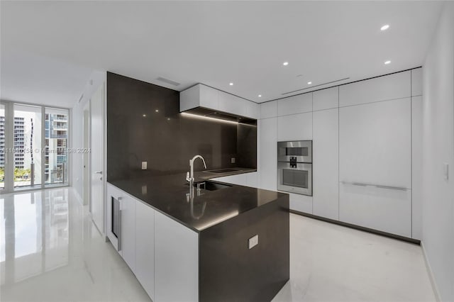 kitchen featuring white cabinets, floor to ceiling windows, and sink