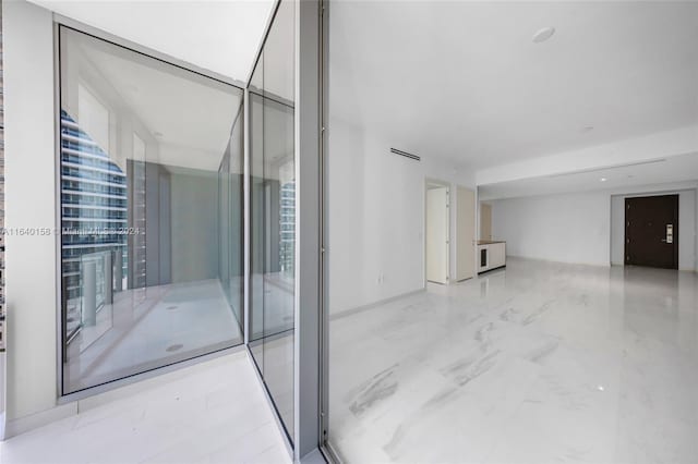 interior space with light tile patterned flooring and a wall of windows