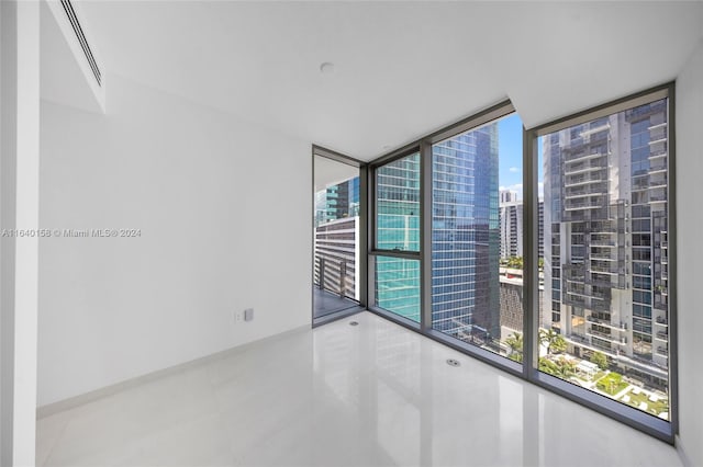 spare room with concrete floors and expansive windows