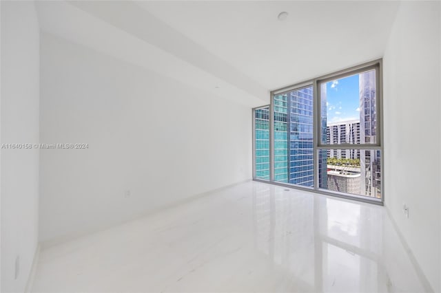 spare room with tile patterned floors and expansive windows