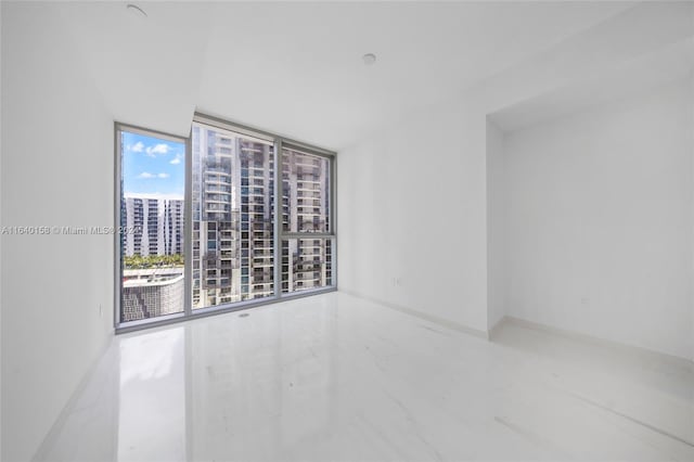 unfurnished room featuring expansive windows