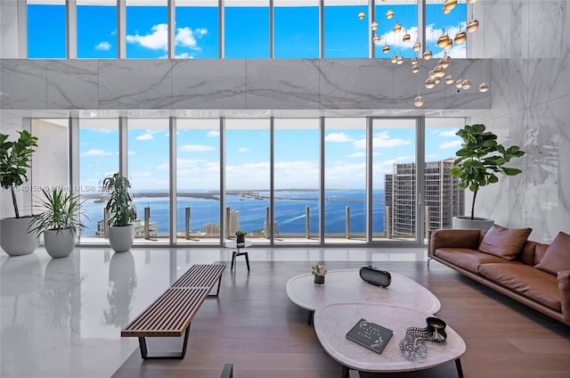 living room featuring a chandelier, a water view, hardwood / wood-style floors, and plenty of natural light