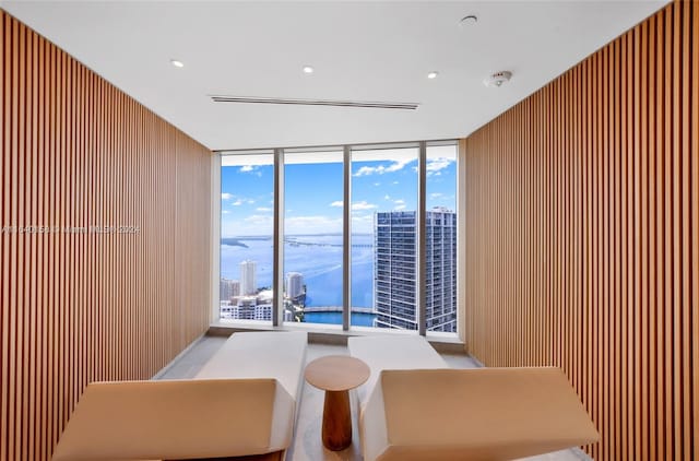 interior space featuring expansive windows, wooden walls, and a water view