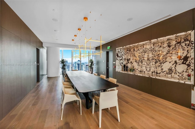 dining room with expansive windows, hardwood / wood-style floors, and a chandelier