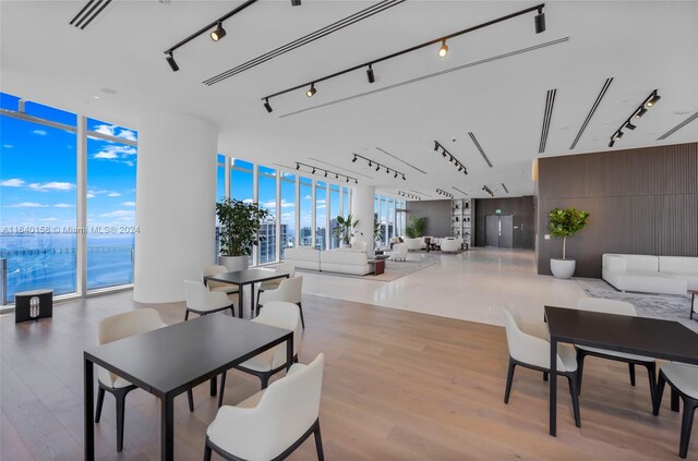 dining room featuring floor to ceiling windows, wood-type flooring, and track lighting