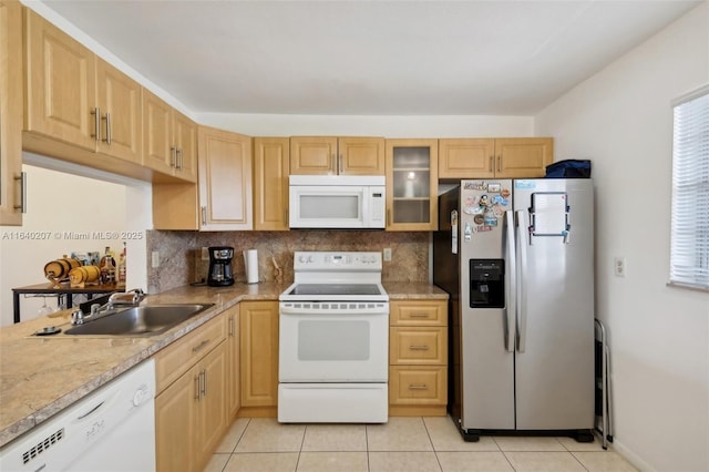 kitchen featuring light brown cabinetry, sink, light tile patterned floors, and white appliances