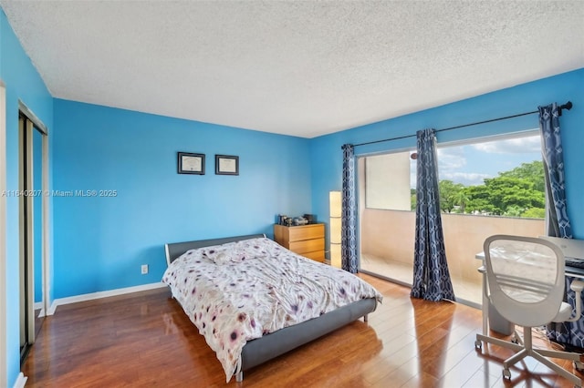 bedroom with a textured ceiling and hardwood / wood-style flooring