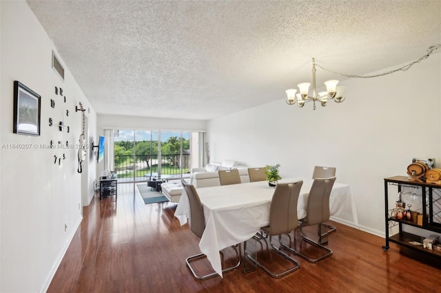 dining room with a notable chandelier, dark hardwood / wood-style floors, and a textured ceiling