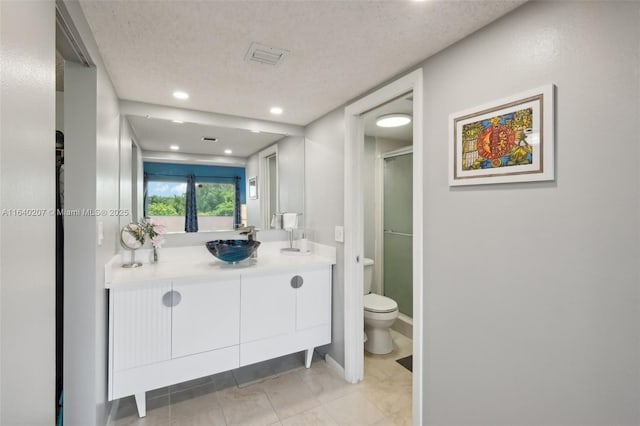 bathroom featuring walk in shower, vanity, a textured ceiling, and toilet