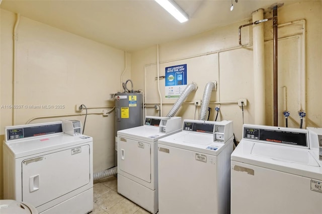 washroom with washing machine and dryer, water heater, and light tile patterned floors