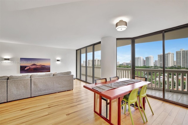 dining area with light wood-type flooring and expansive windows