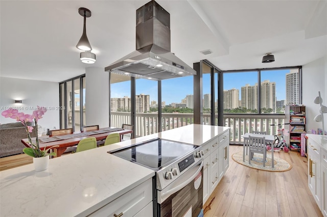 kitchen featuring island exhaust hood, white cabinetry, stainless steel electric stove, and light hardwood / wood-style flooring