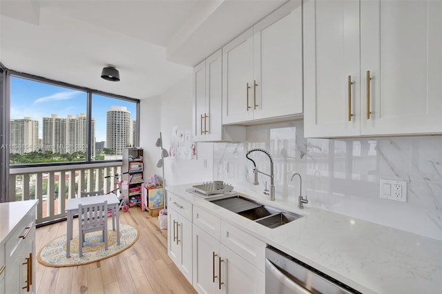 kitchen featuring decorative backsplash, sink, light stone countertops, and light hardwood / wood-style floors