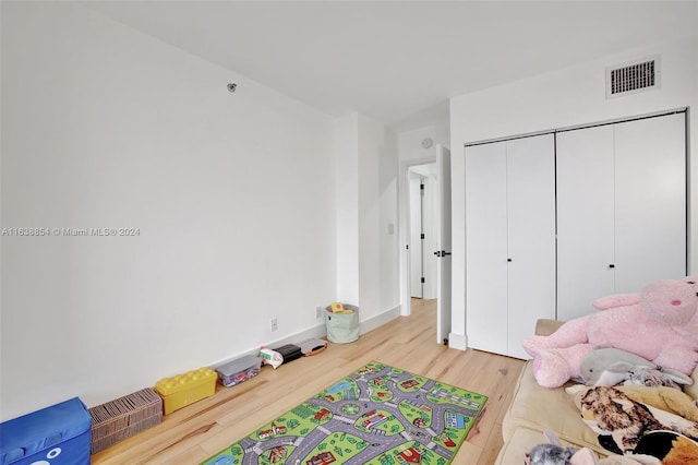 bedroom with light wood-type flooring and a closet