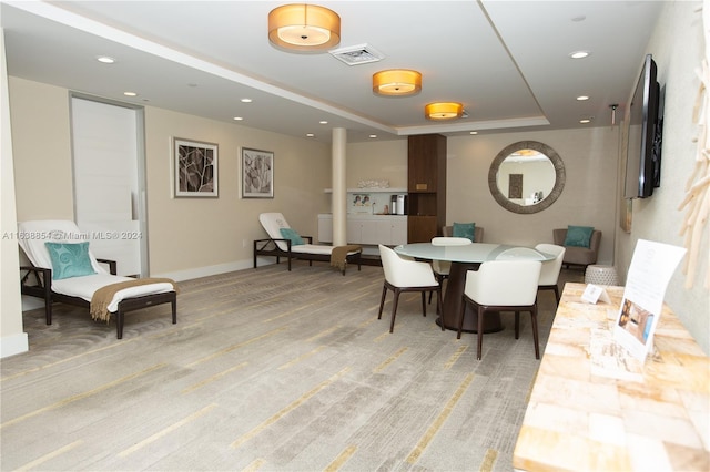 dining room with carpet flooring and a raised ceiling