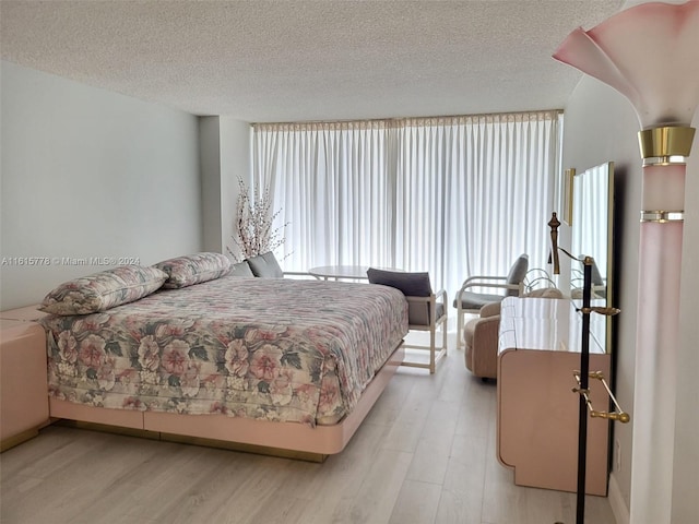 bedroom with light hardwood / wood-style flooring and a textured ceiling