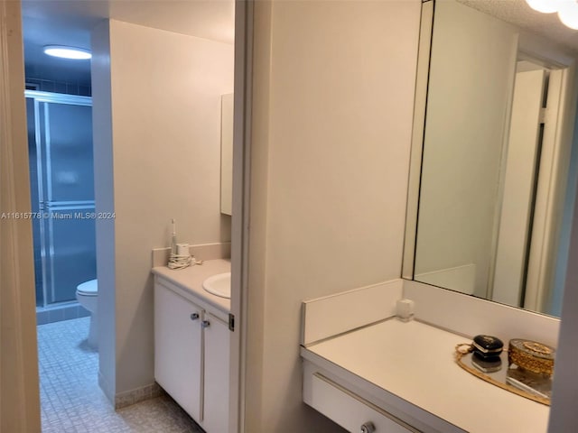 bathroom with toilet, vanity, and tile patterned flooring