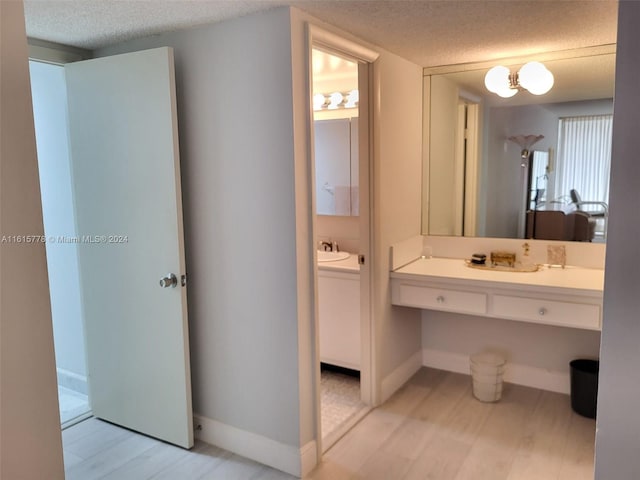 bathroom featuring hardwood / wood-style floors, a textured ceiling, and vanity