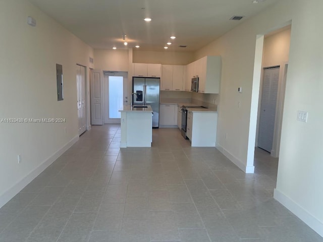 kitchen with white cabinetry, appliances with stainless steel finishes, light tile patterned floors, a center island, and sink