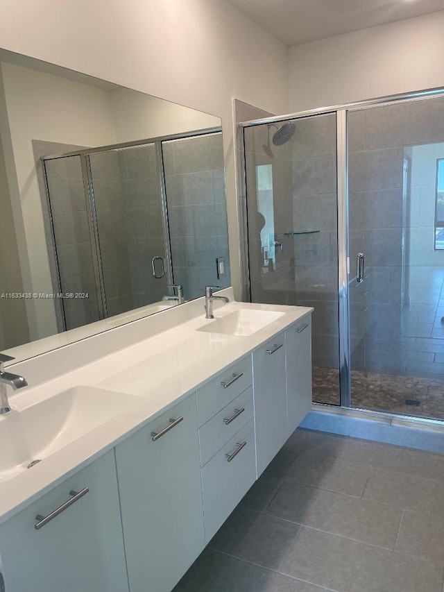 bathroom with dual vanity, walk in shower, and tile patterned flooring