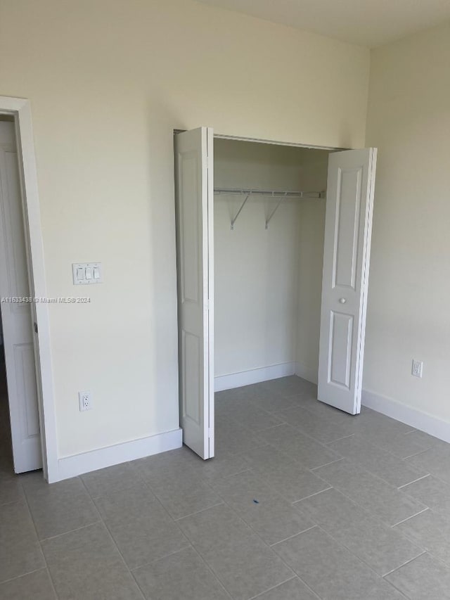 unfurnished bedroom with a closet and light tile patterned floors