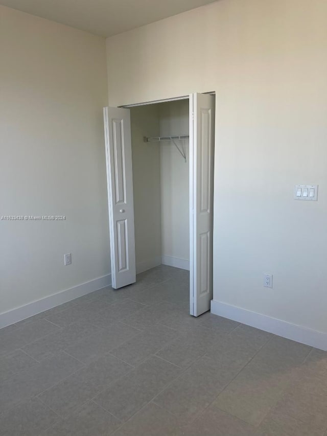 unfurnished bedroom featuring tile patterned flooring and a closet