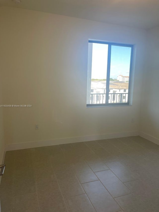 tiled spare room featuring plenty of natural light