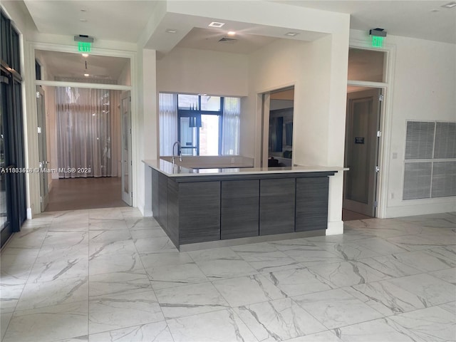 kitchen with light tile patterned flooring, sink, and a center island