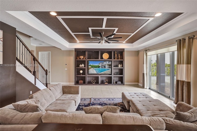 tiled living room featuring ceiling fan and a raised ceiling