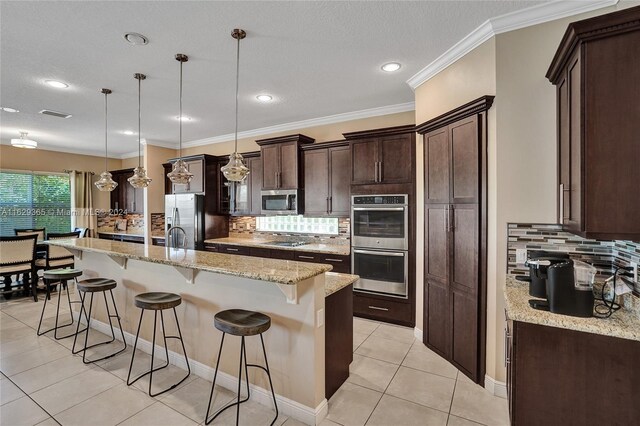 kitchen with appliances with stainless steel finishes, crown molding, tasteful backsplash, and hanging light fixtures