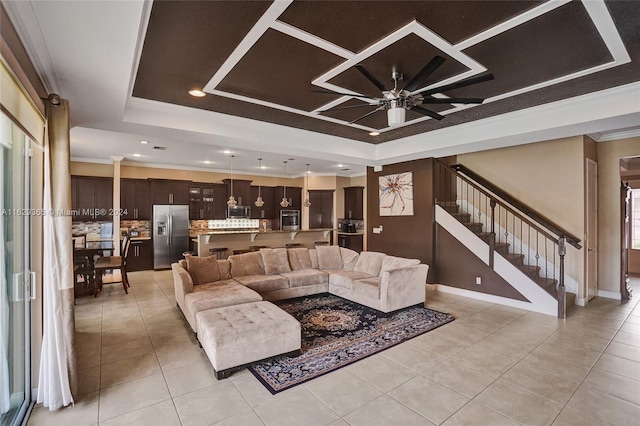 living room featuring ceiling fan, light tile patterned flooring, a raised ceiling, and crown molding