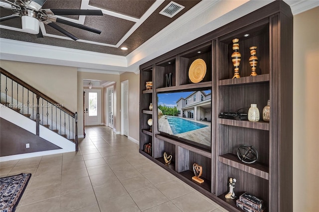 tiled foyer featuring ceiling fan and crown molding