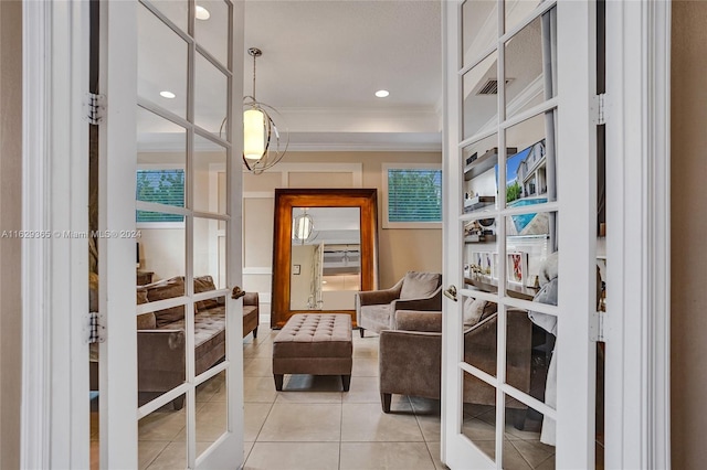 sitting room featuring crown molding, french doors, and light tile patterned floors