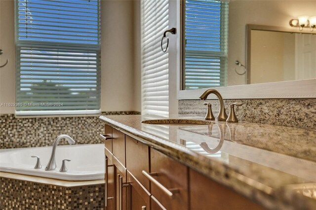 bathroom featuring vanity and a relaxing tiled tub