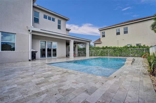 view of swimming pool with grilling area and a patio area