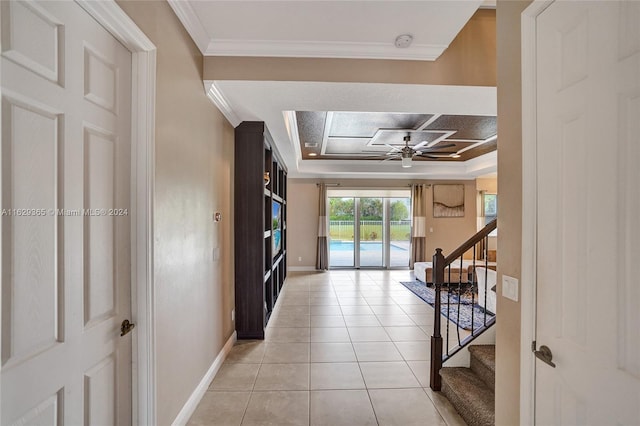 hall featuring a raised ceiling, light tile patterned flooring, coffered ceiling, and crown molding