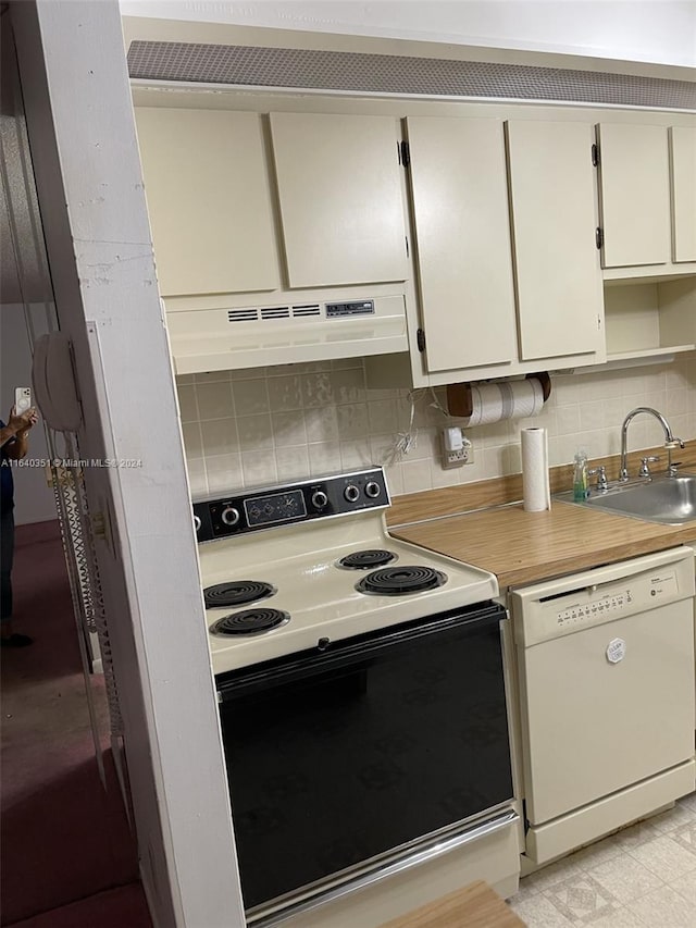 kitchen with white cabinetry, white appliances, backsplash, premium range hood, and sink