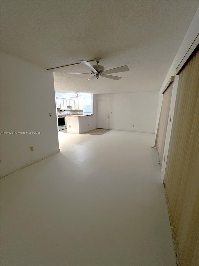 unfurnished living room with a textured ceiling and ceiling fan