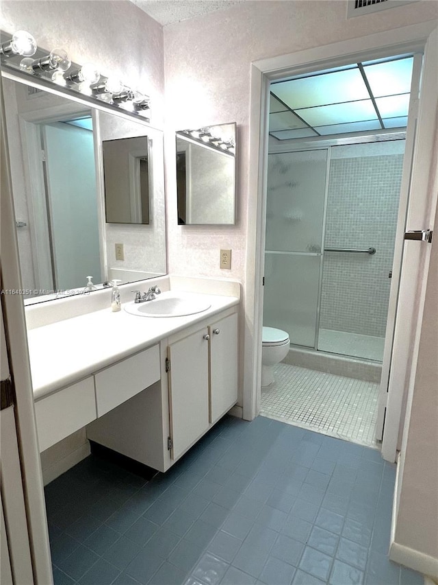 bathroom with walk in shower, vanity, toilet, and tile patterned flooring