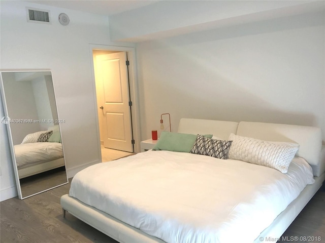 bedroom with hardwood / wood-style floors and a closet