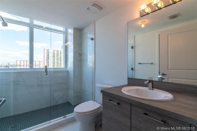 bathroom featuring tile patterned floors, vanity, a shower with door, and toilet