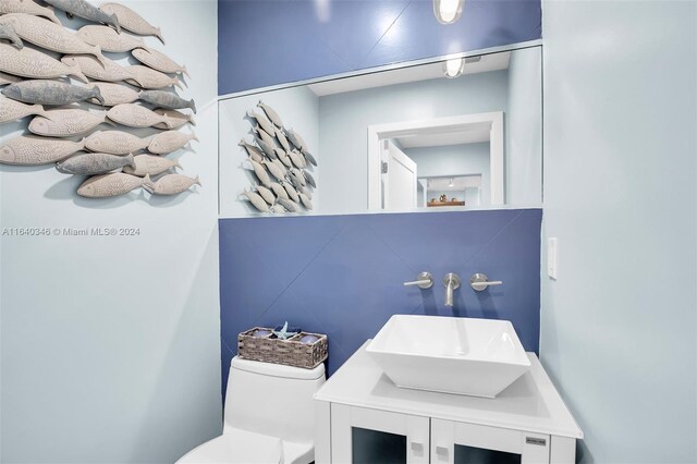 bathroom with vanity, decorative backsplash, and toilet