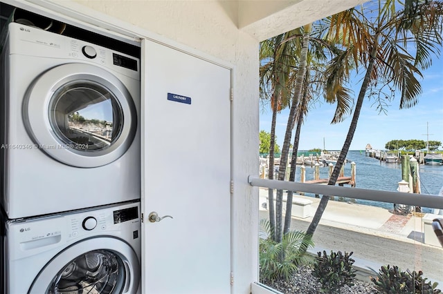 laundry area featuring stacked washer and dryer and a water view