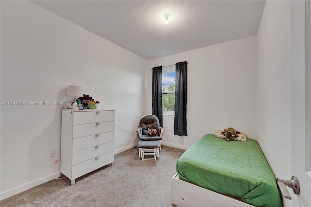 bedroom with light colored carpet and a textured ceiling